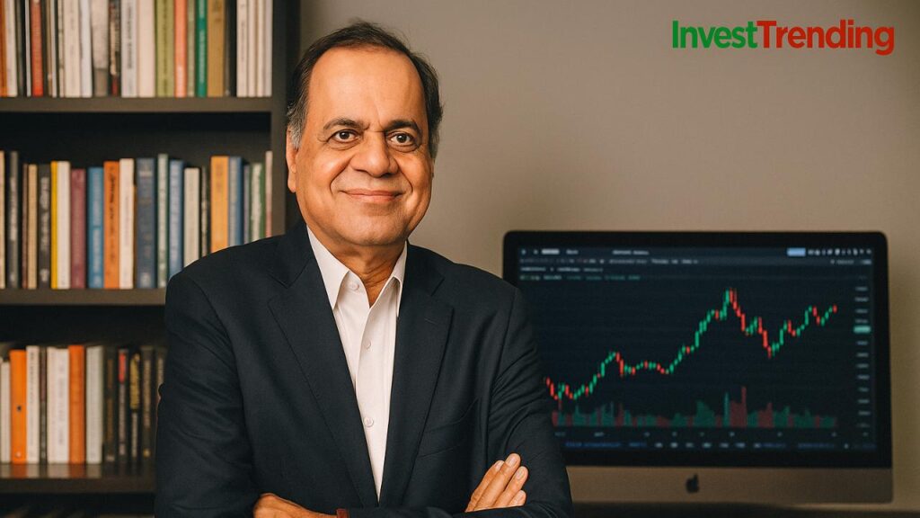 Ramesh Damani in a navy blue suit standing confidently in front of a bookshelf and a computer displaying a trading chart, with the InvestTrending brand logo in the top-right corner.